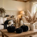 Elegant Halloween living room with black velvet pumpkins, brass candlesticks and cream decor